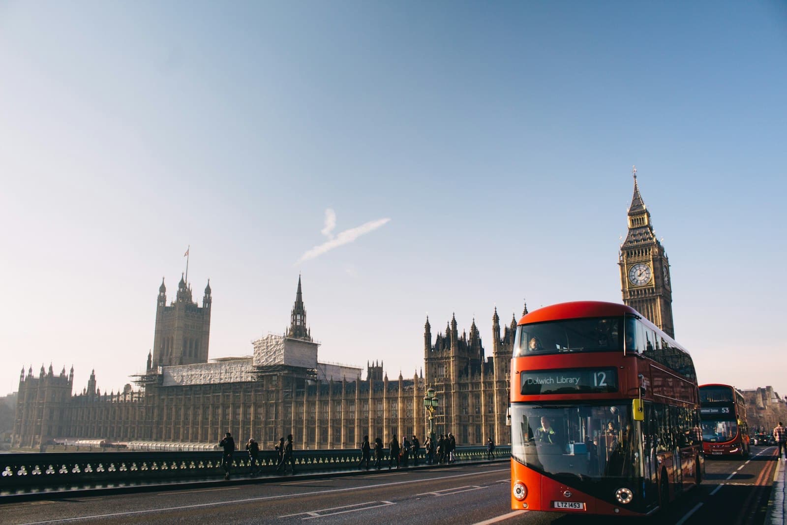 A red double-decker bus passing Big Ben in London